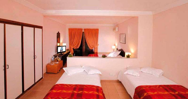 Doppelzimmer im Royal Decameron Issil Resort mit zwei Betten, Fernseher und Schrank.