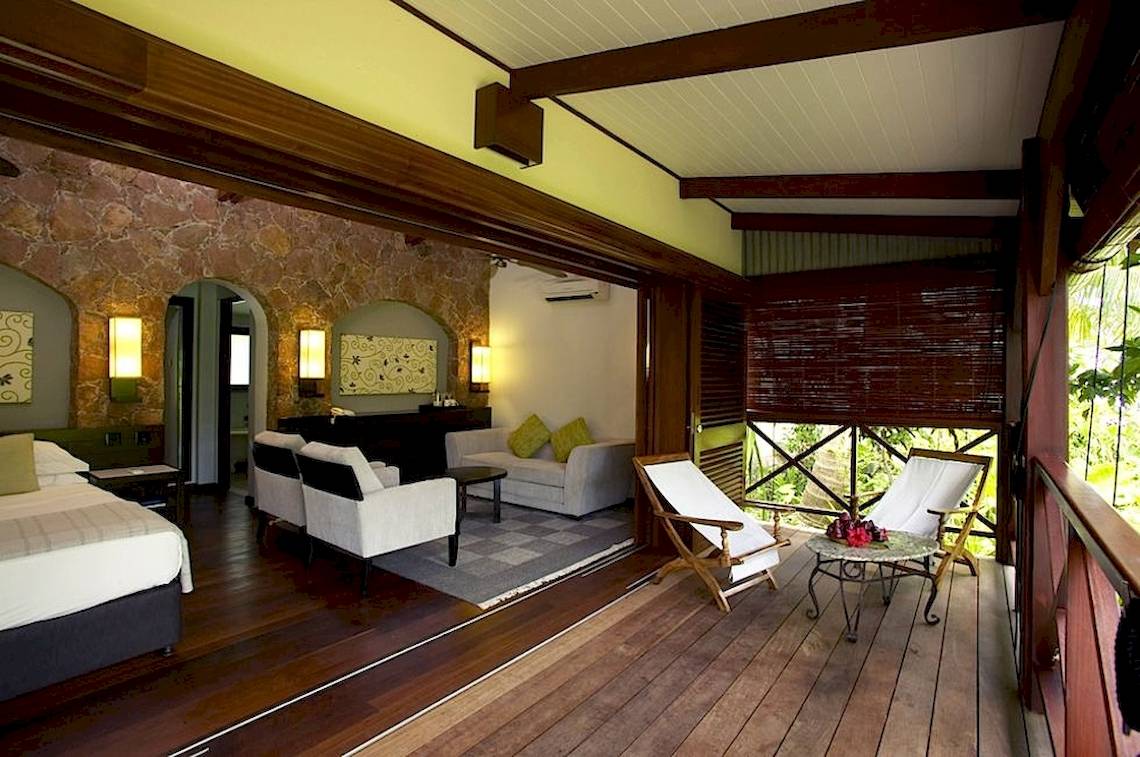 Innenraum des Paradise Sun Hotels mit Bett, Wohnzimmer und Balkonmöbeln.