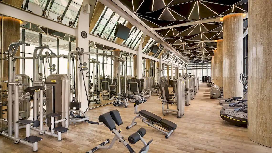 Fitnesscenter im Grand Hyatt Abu Dhabi Hotel mit vielen Trainingsgeräten und Spiegeln.