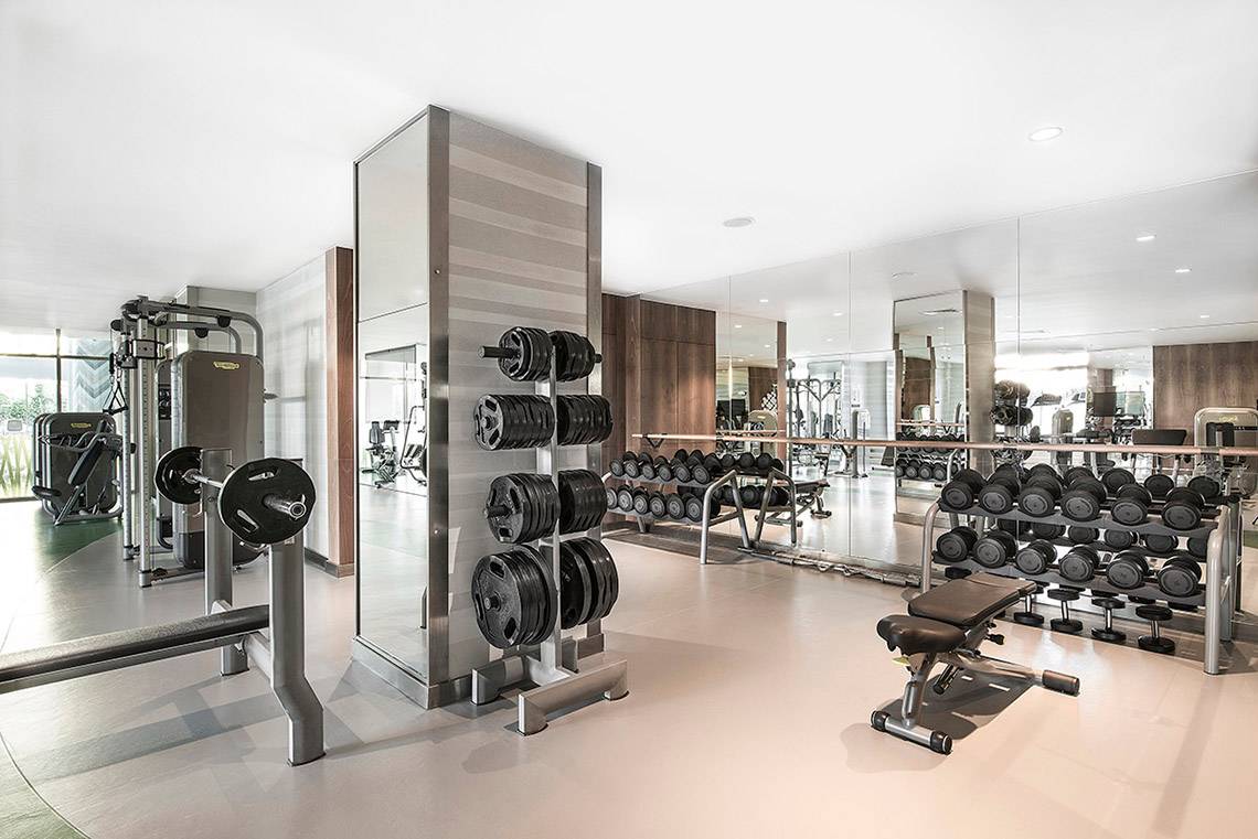 Fitnesscenter im Titanic Deluxe Lara Hotel mit verschiedenen Trainingsgeräten und Spiegeln.