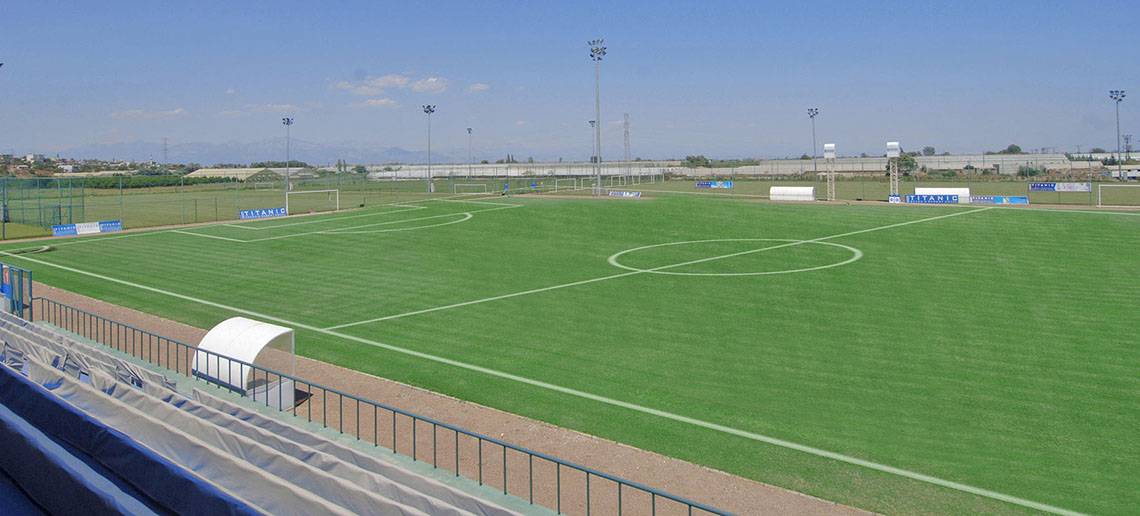 Leerer Fußballplatz des Titanic Deluxe Lara Hotels mit blauer Begrenzung und Sonnenlicht