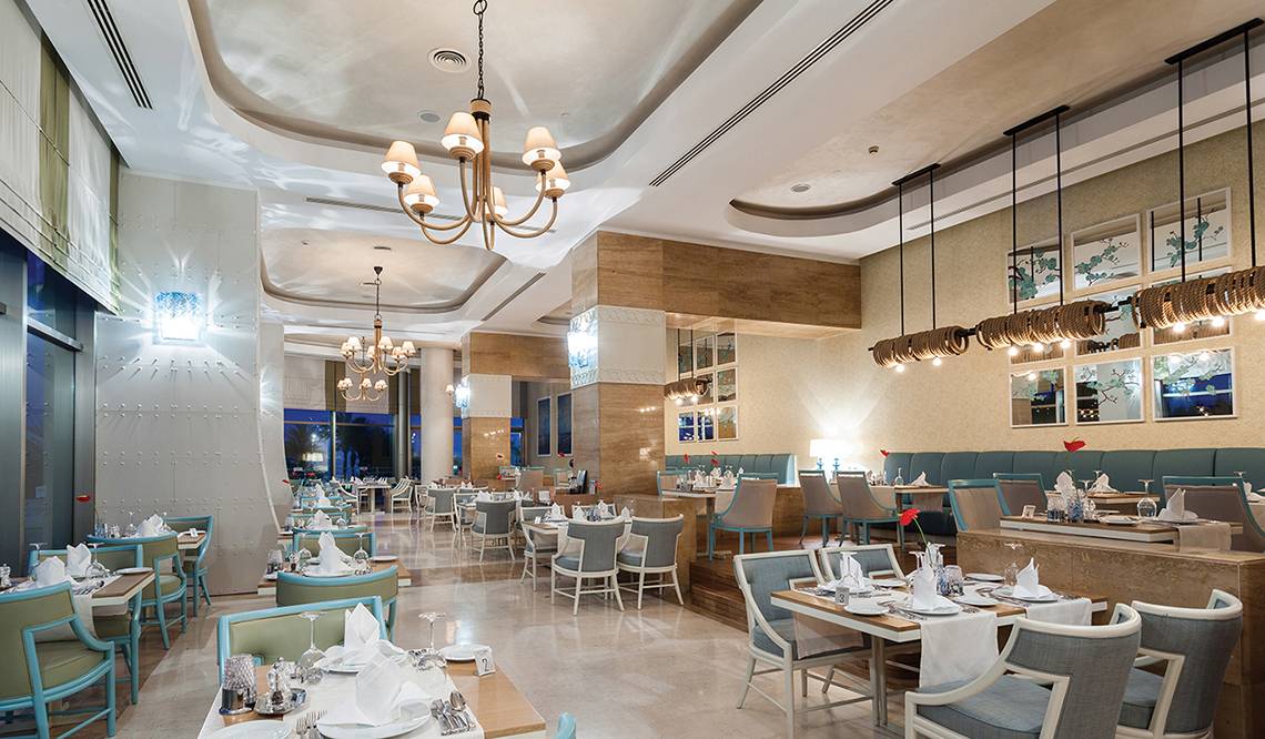 Innenbereich des Titanic Deluxe Lara Restaurants mit modernen Möbeln und eleganten Beleuchtungskörpern.