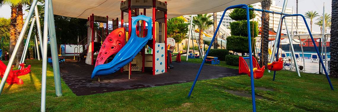 Spielplatz im Freilichtbereich des Titanic Deluxe Lara Hotels mit Rutsche und Schaukeln