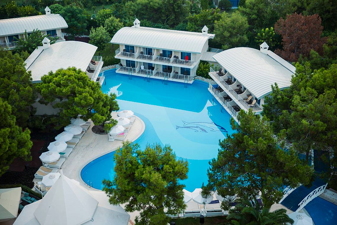 Luftaufnahme des Titanic Deluxe Lara Hotels mit Swimmingpool und Sonnenliegen.