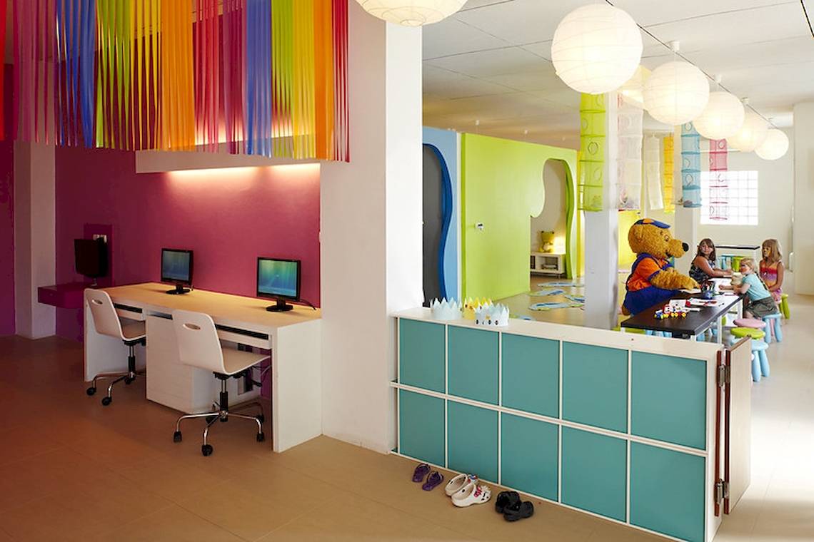 Kinderbetreuungsbereich im Sunwing Kamala Beach Hotel mit bunten Farben und Teddybären-Maskottchen.
