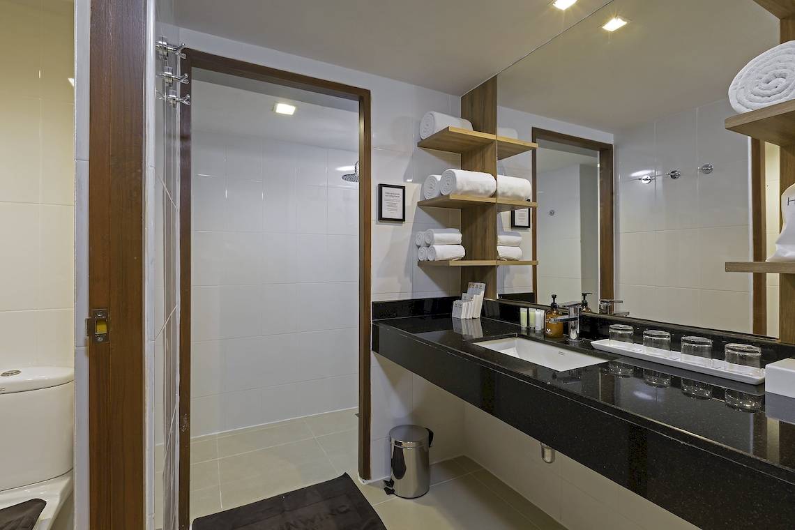 Badezimmer im Sunwing Kamala Beach Hotel mit Duschbereich, Waschbecken und Toilette.