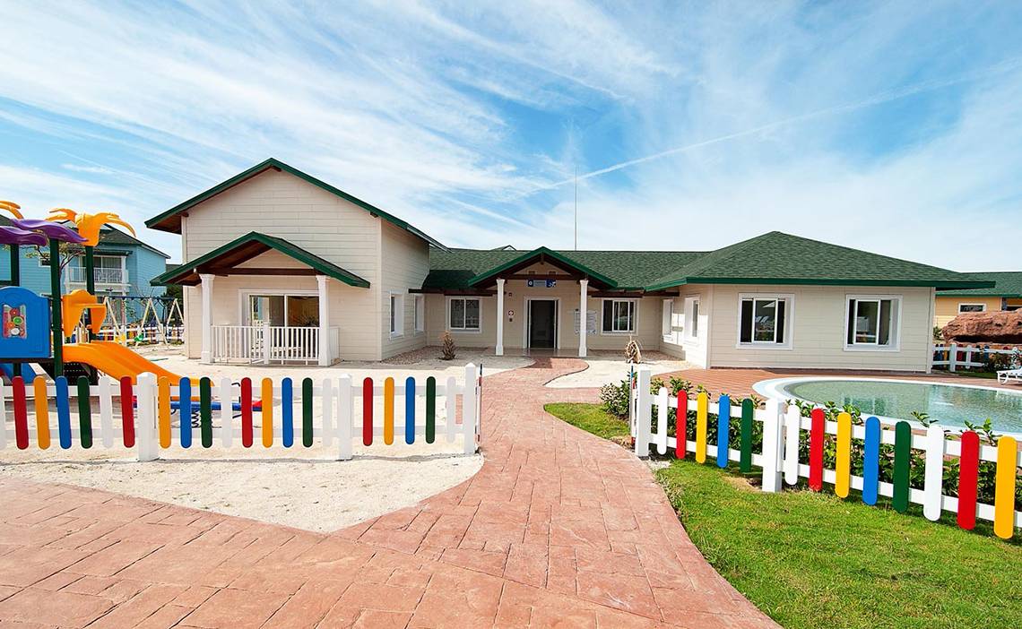 Außenansicht des Valentin Varadero El Patriarca Hotels mit buntem Spielplatz und Pool.