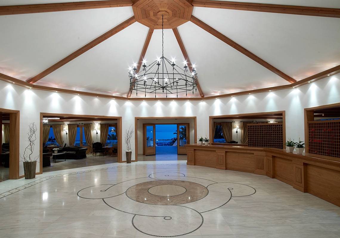 Lobby des Mitsis Rinela Beach Hotels mit Kronleuchter und Marmorboden.
