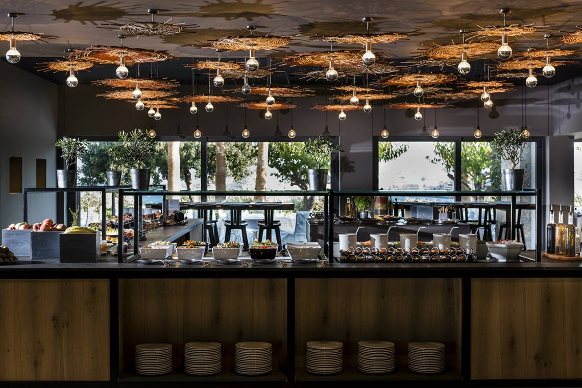 Frühstücksbuffet im Minos Palace Hotel & Suites mit verschiedenen Speisen und Früchten.