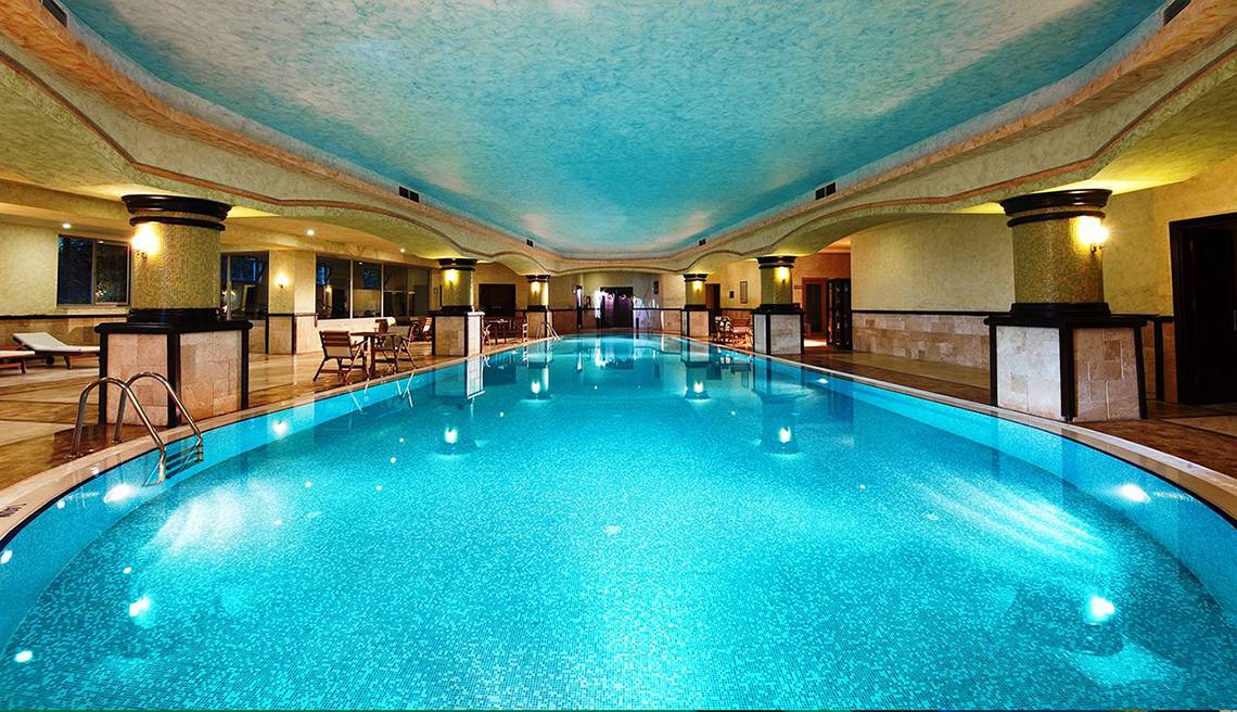Ein großer Innenpool im Side Sun Hotel mit blauen Fliesen und einer blauen Decke.