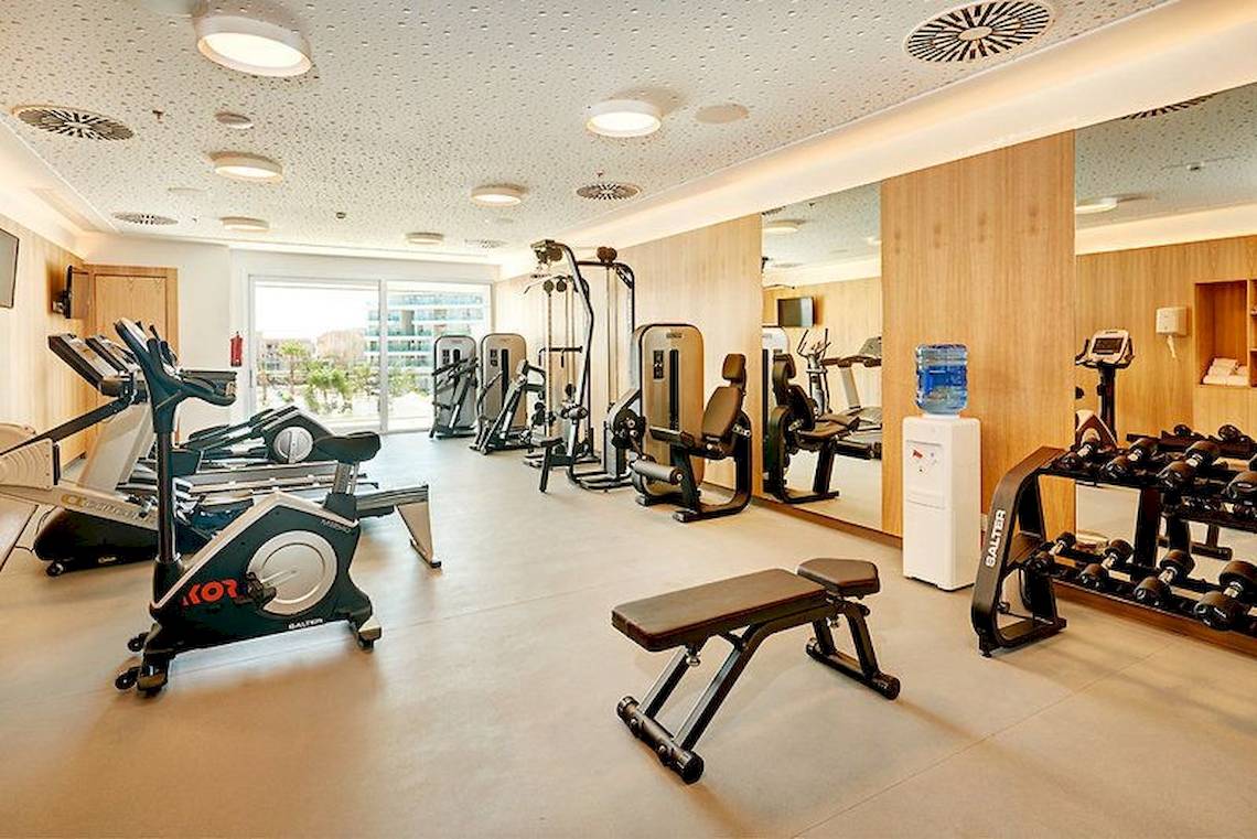 Fitnesscenter im Hipotels Playa de Palma Palace Hotel mit verschiedenen Geräten und einem Wasserspender.