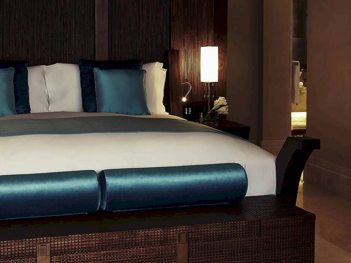Sofitel Dubai The Palm Schlafzimmer mit blauen Kissen und Lampe