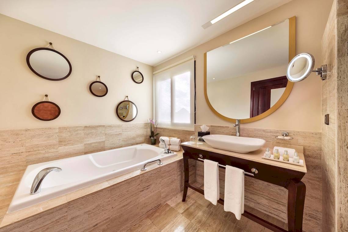Badezimmer im Grand Palladium White Sand Resort & Spa mit Badewanne, Waschbecken und Spiegeln.
