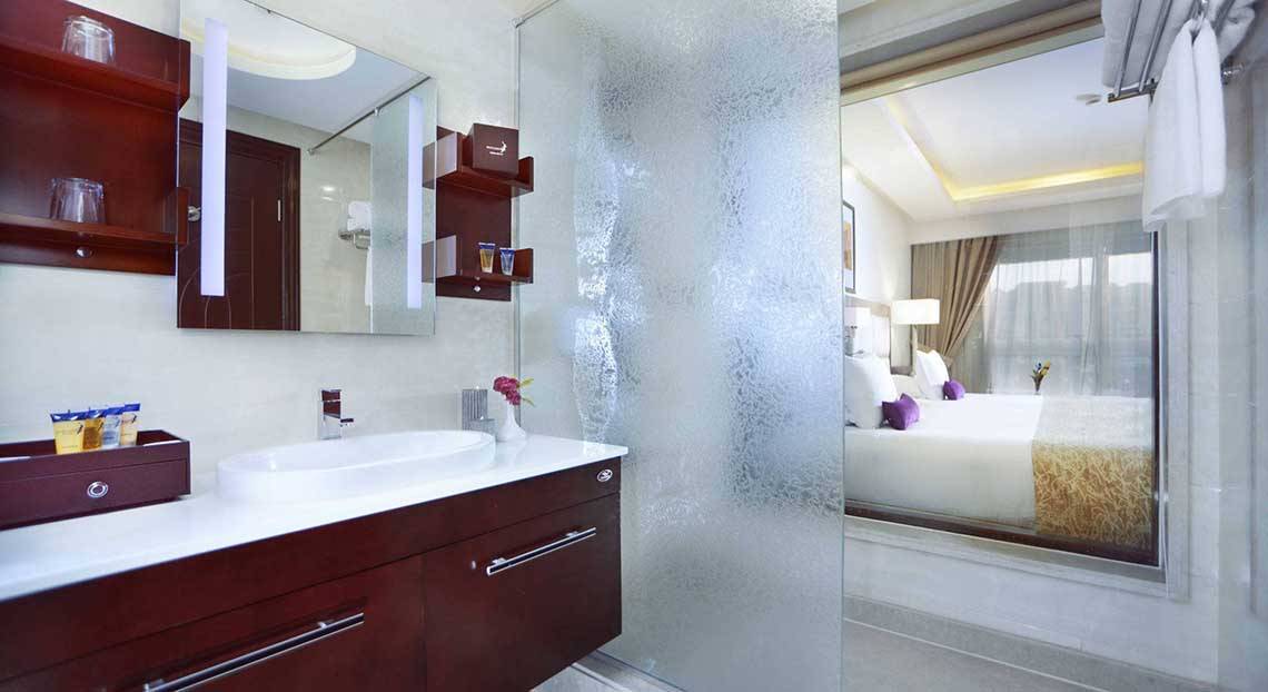 Badezimmer-Ansicht des Pickalbatros White Beach Resort Hotelzimmers mit Waschbecken und Spiegel.