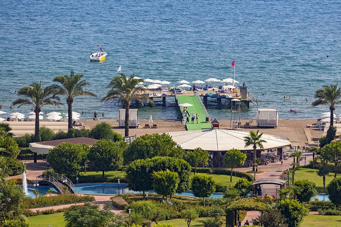 Wunderschoenes Resort am Meer mit Booten und Palmen