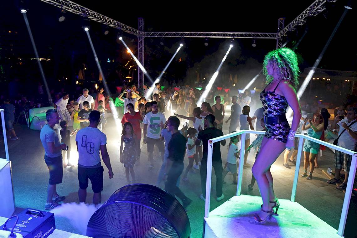 Nachtclub-Feier im Miracle Resort mit vielen tanzenden Gästen und einer Frau auf der Bühne.