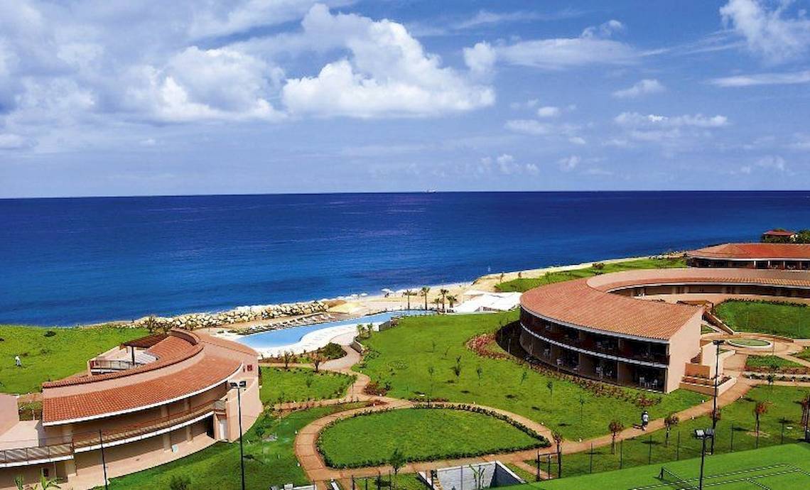 Außenansicht des Capovaticano Resort Thalasso Spa mit Meer und Gebäuden
