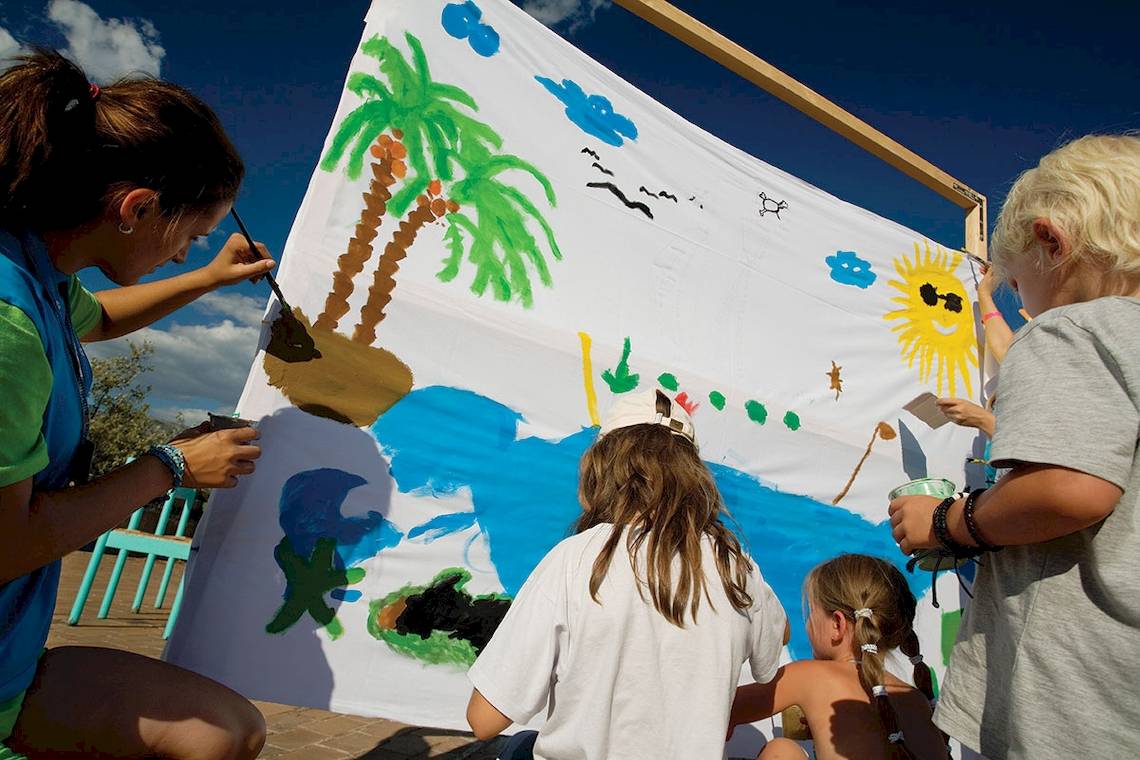 Kinder malen an einer großen Wand im Freien im Club Dubrovnik Hotel.