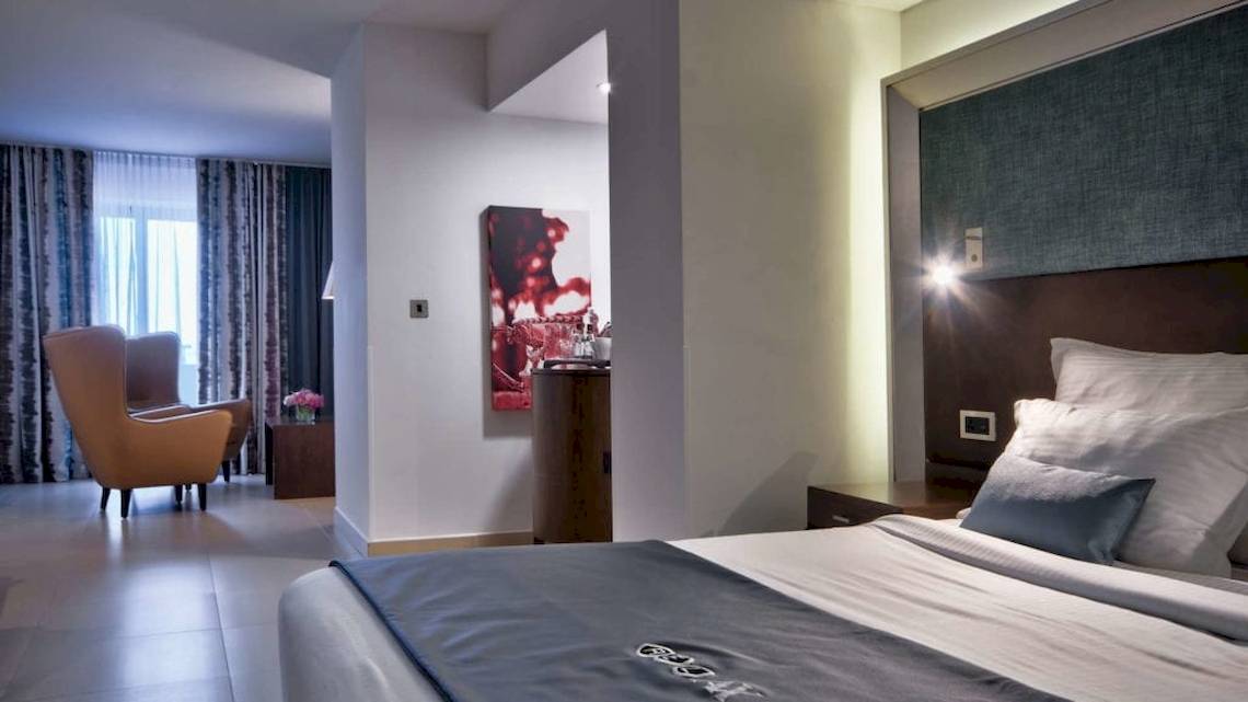 Schlafzimmer im AX The Palace Hotel mit Bett, Kissen, Dekor und Möbeln.