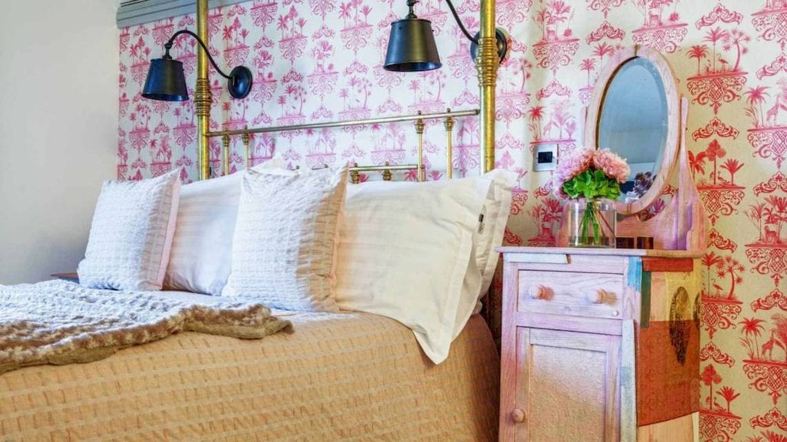 Ein Bett mit weißen Kissen und einem goldfarbenen Bettrahmen im AX The Palace Hotel.
