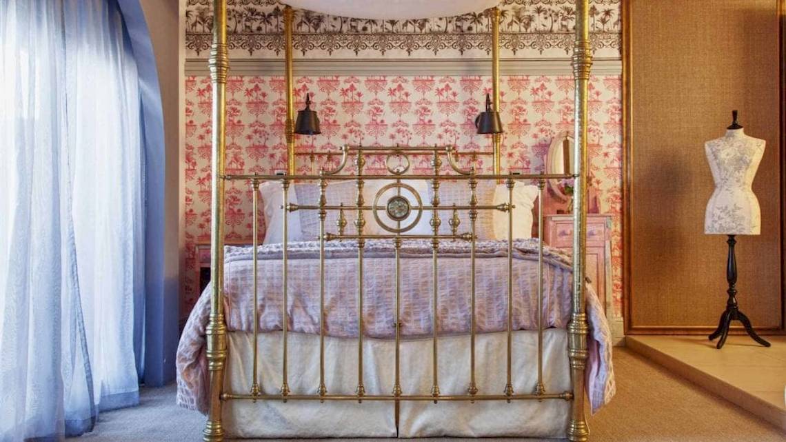 Schlafzimmer im AX The Palace Hotel mit einem viktorianischen Bett und rosa Tapeten.