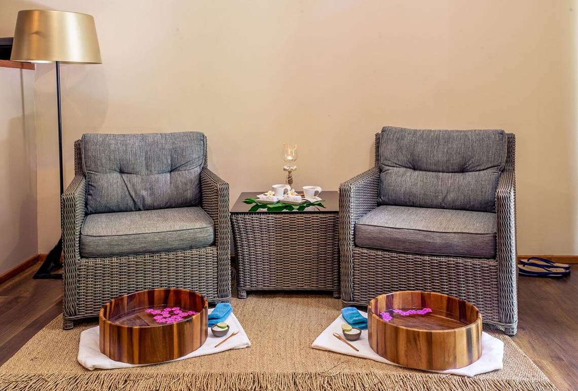 Massagebereich im Kudafushi Resort & Spa mit zwei Sessel und Wasserschalen.