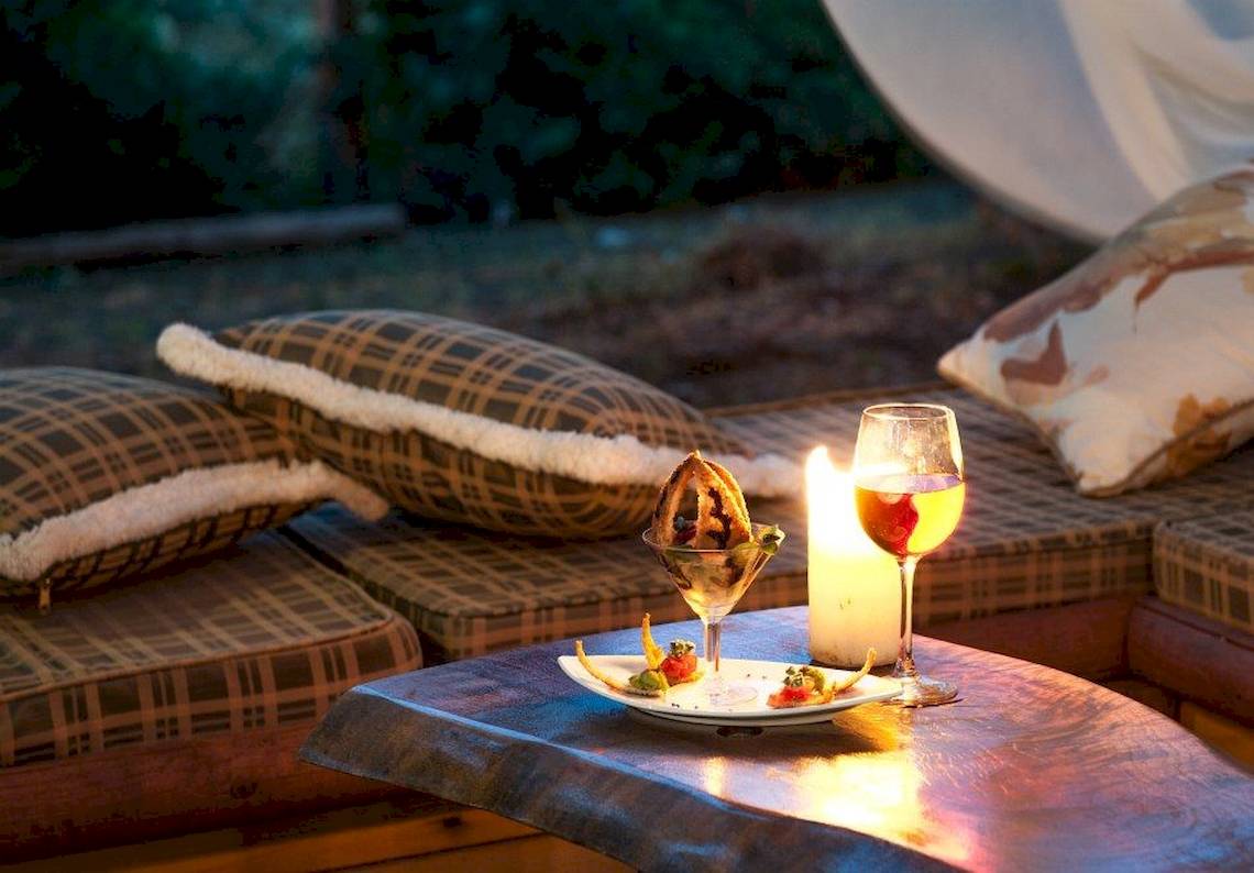 Abendessen auf der Couch im Hotel Belvedere mit Essen, Wein und Kerzenlicht.