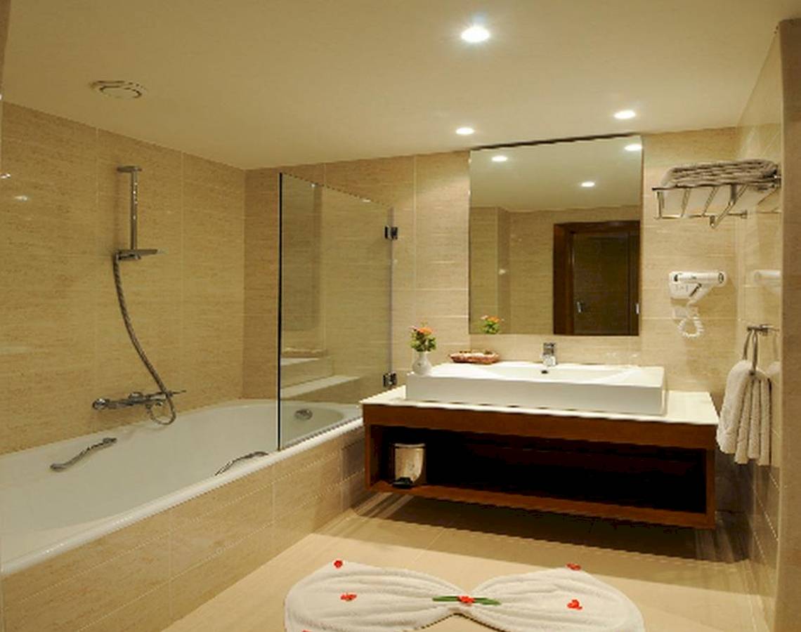 Ein Badezimmer mit Badewanne, Waschbecken und Spiegel im Vincci Helios Beach Hotel.