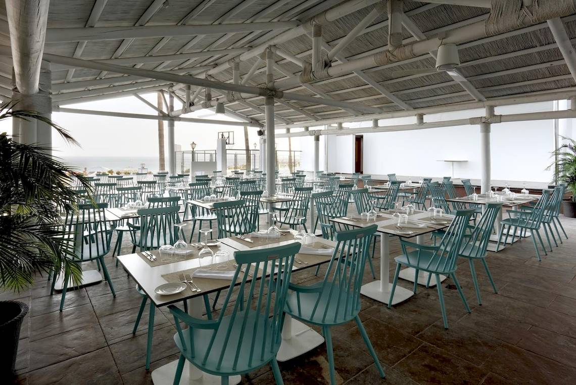 Innenansicht des Restaurants des Playabonita Hotels mit türkisfarbenen Stühlen und Tischen.