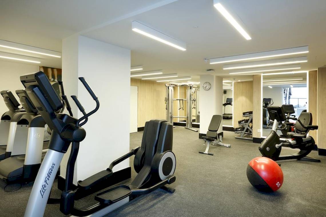 Fitnessraum im Playabonita Hotel mit Laufbändern, Rudergeräten und einer roten Gymnastikkugel.