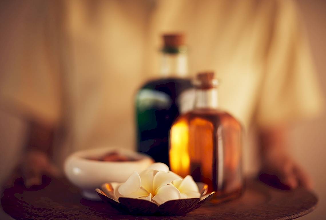 Tablett mit Aromatherapie-Flaschen und Blumen im Jetwing Blue Hotel.