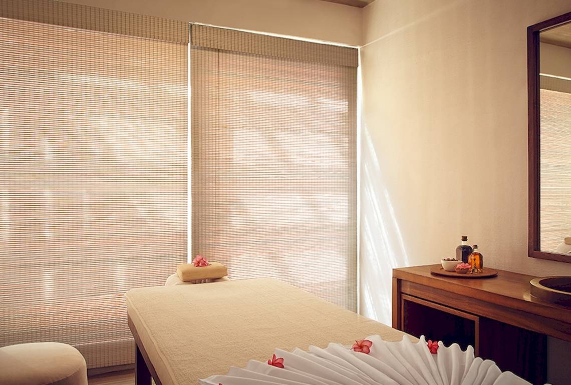 Spa-Behandlungsraum im Jetwing Blue Hotel mit Bambusrollos und Massagetisch.