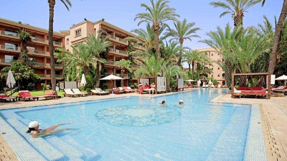 Schwimmbad des Sofitel Marrakech Lounge & Spa Hotels mit mehreren Schwimmern und Sonnenliegen.