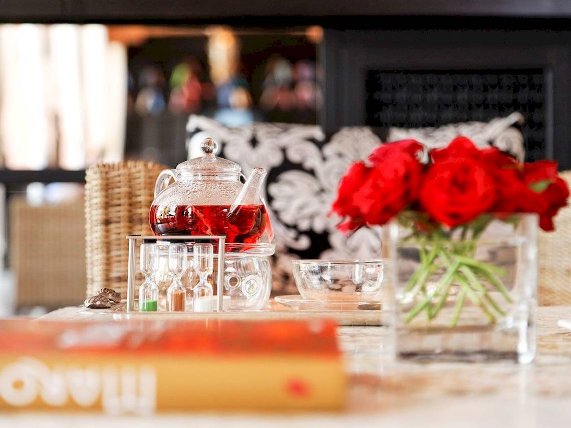 Tisch mit Teekannen, Gläsern und roten Rosen im Sofitel Marrakech Lounge.