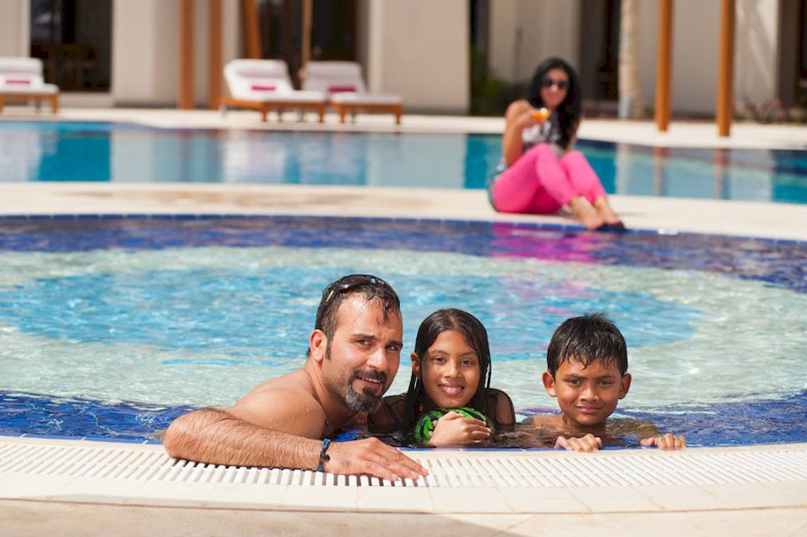 Familie im Pool im Sifawy Boutique Hotel mit einer Frau am Rand