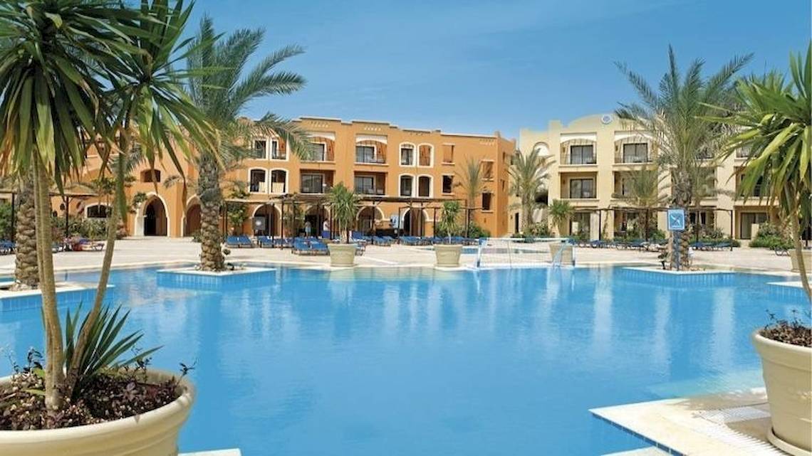 Außenbereich des JAZ Neo Dar El Madina Hotels mit Swimmingpool und Palmen
