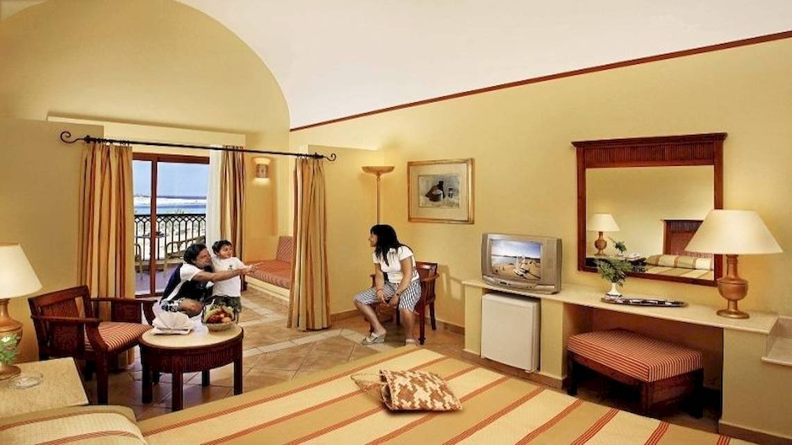 Hotelzimmer im Jaz Dar El Madina mit Familie, Fernseher, Spiegel und Fenster mit Meerblick.