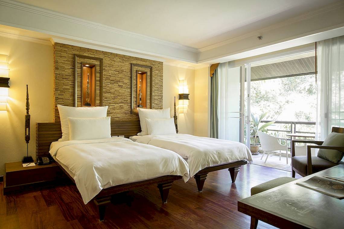 Doppelbettzimmer im Robinson Khao Lak Hotel mit zwei Betten, offenem Balkon und Blick auf den Garten.