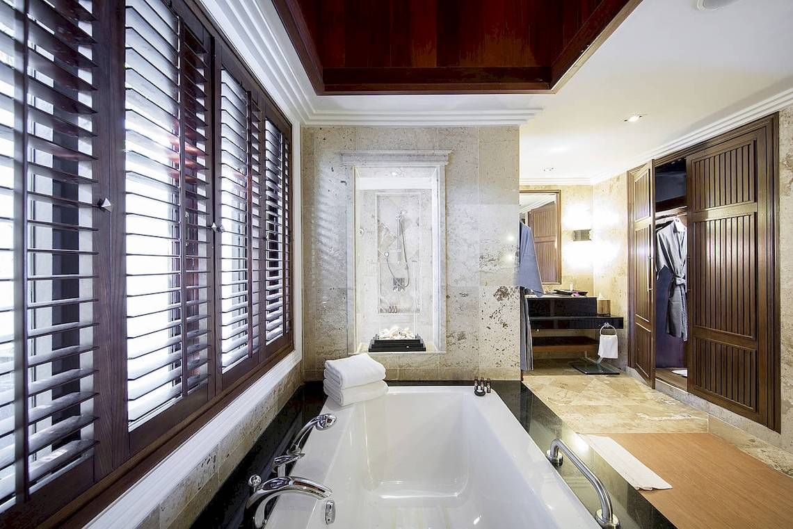 Badezimmer im Robinson Khao Lak Hotel mit Badewanne, Dusche und Holzelementen.