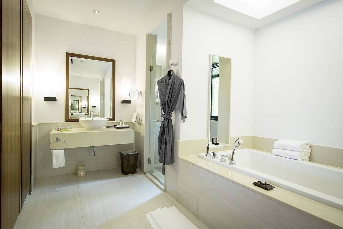 Badezimmer im Robinson Khao Lak Hotel mit Badewanne, Dusche und Waschbecken.