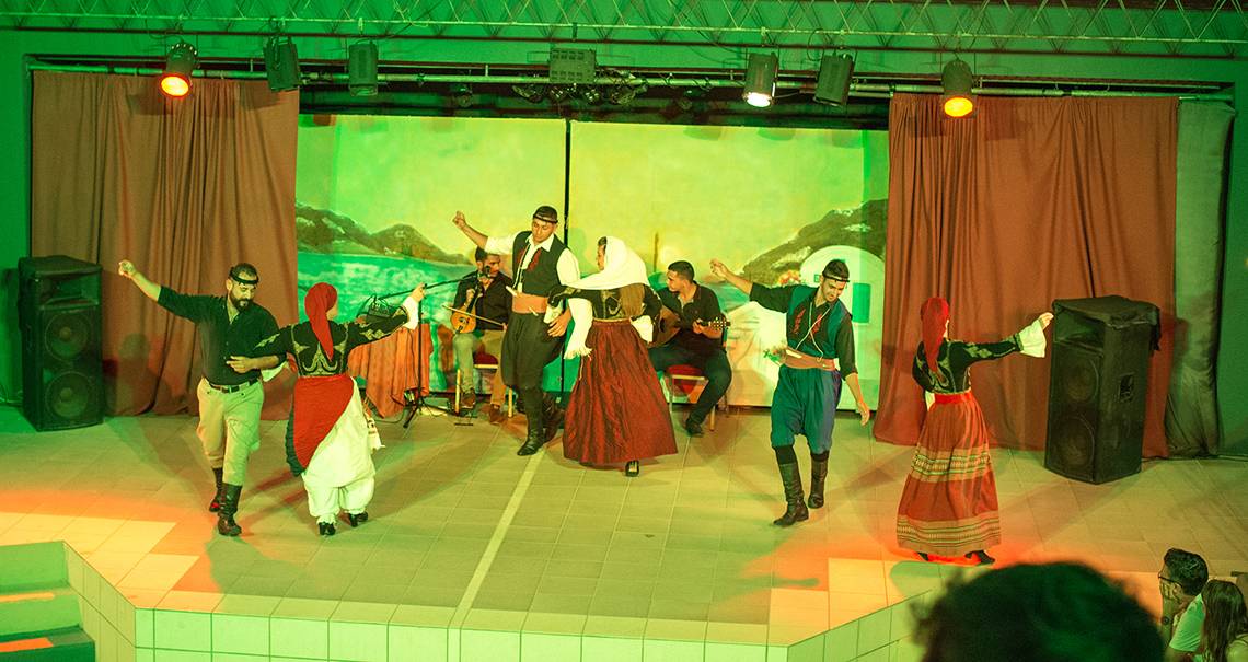Gruppe von Tänzern und Musikern tritt auf einer Bühne im Grand Hotel Holiday Resort auf