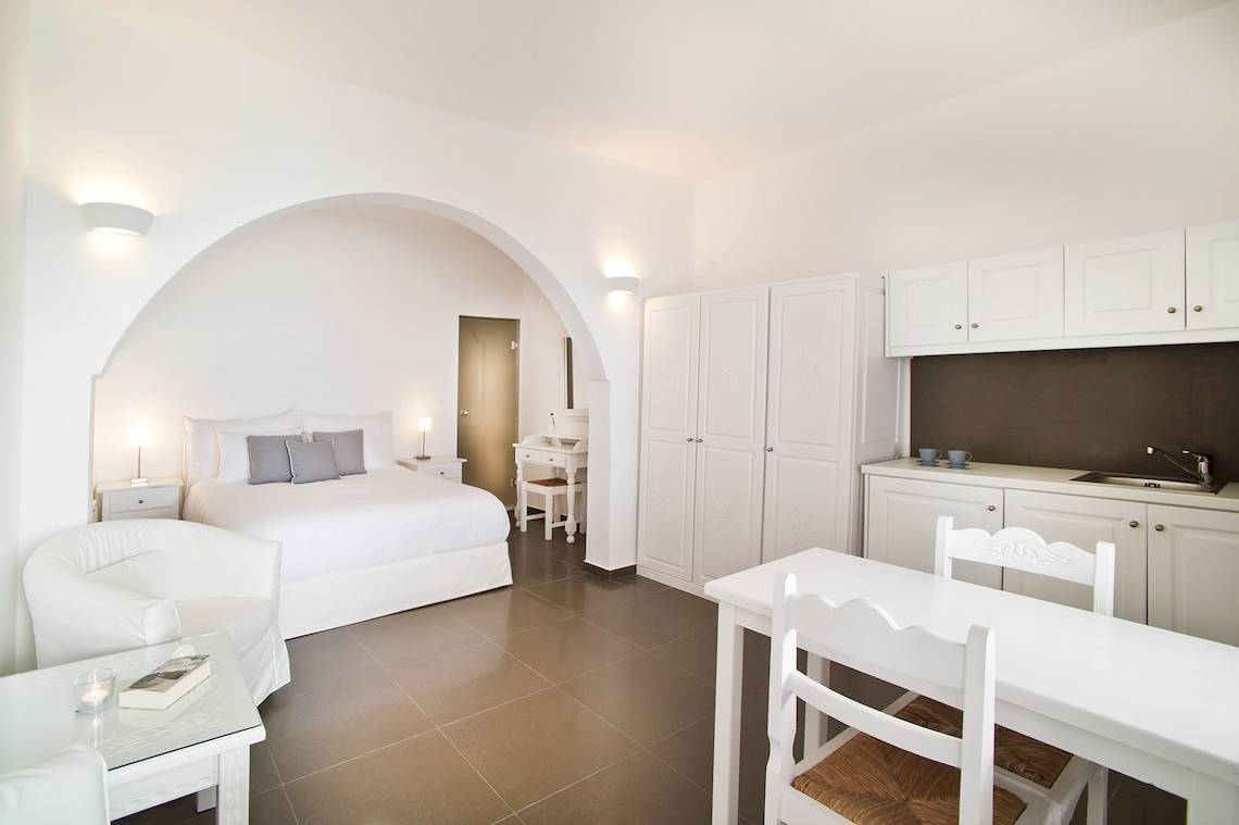 Ein modernes Schlafzimmer und Küche im Agali Houses Hotel mit weißen Möbeln und einer gefliesten Oberfläche.