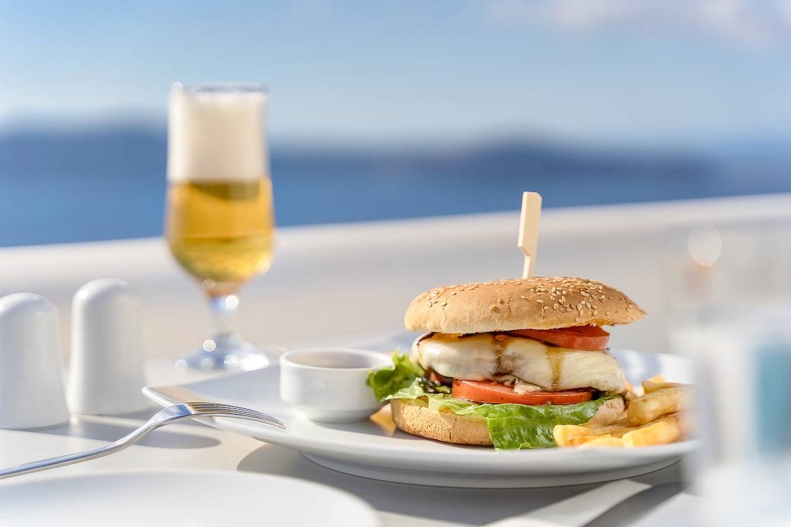 Gerichteter Teller mit Burger, Pommes und Getränk auf der Terrasse der Agali Houses.