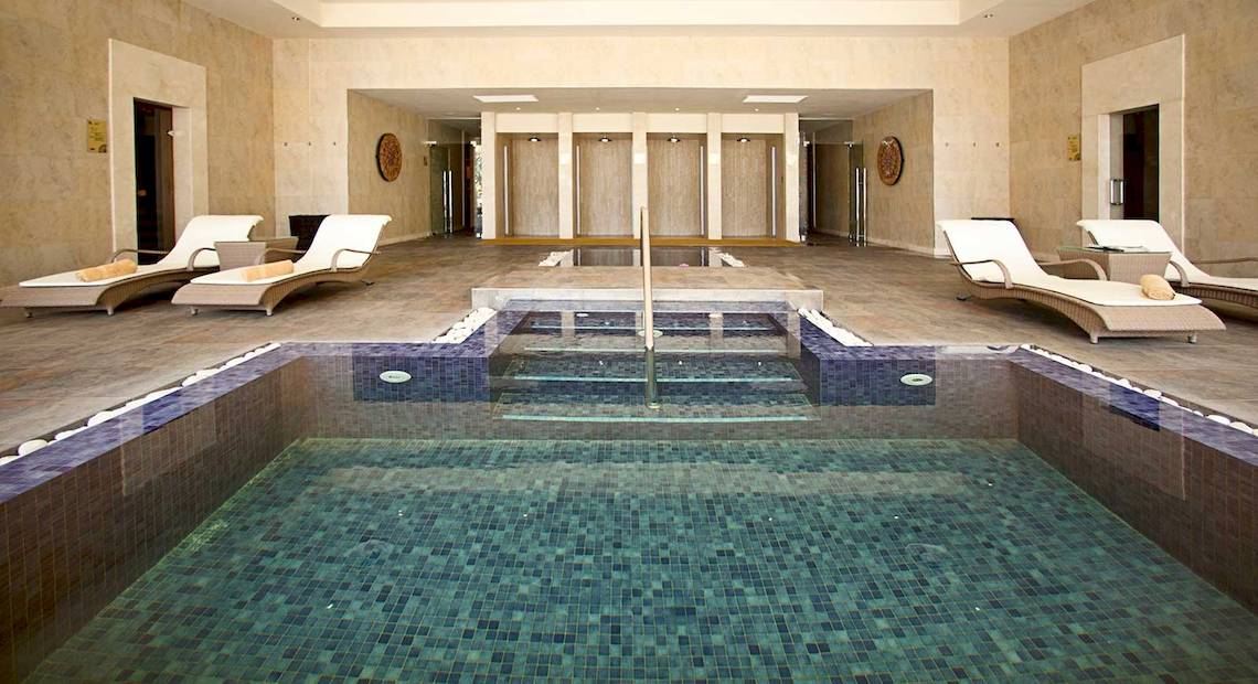 Innenpool im Barcelo Bavaro Palace mit Loungeliegen und Fliesenboden