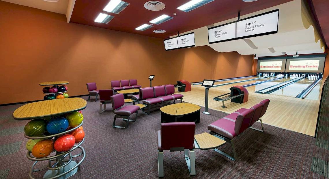 Innenansicht der Bowlinghalle im Barcelo Bavaro Palace Hotel mit Bowlingbahnen, roten Stühlen und Bowlingkugeln.