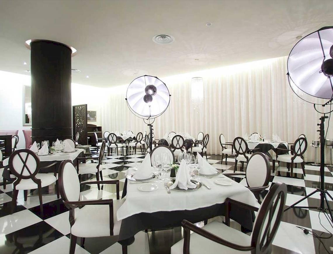 Restaurant des Barcelo Bavaro Palace mit schwarzem und weißem Schachbrettboden und weißen Tischen.