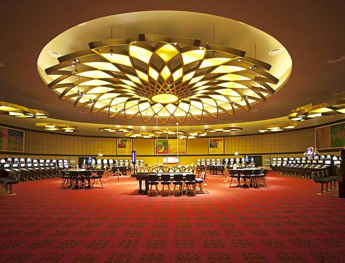 Casino im Barcelo Bavaro Palace mit großen Tischen und Spielautomaten.