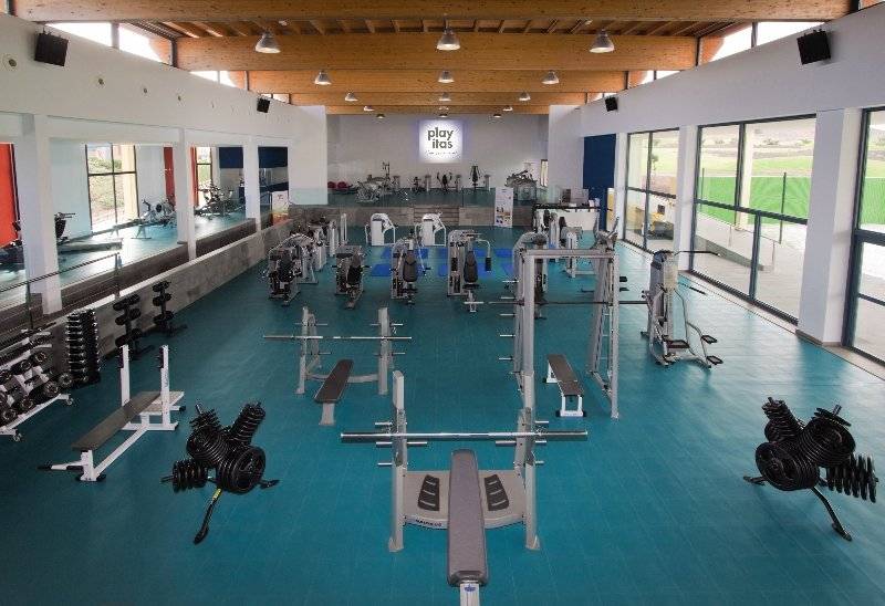 Fitnesscenter im Playitas Hotel mit vielen Geräten und blauen Boden