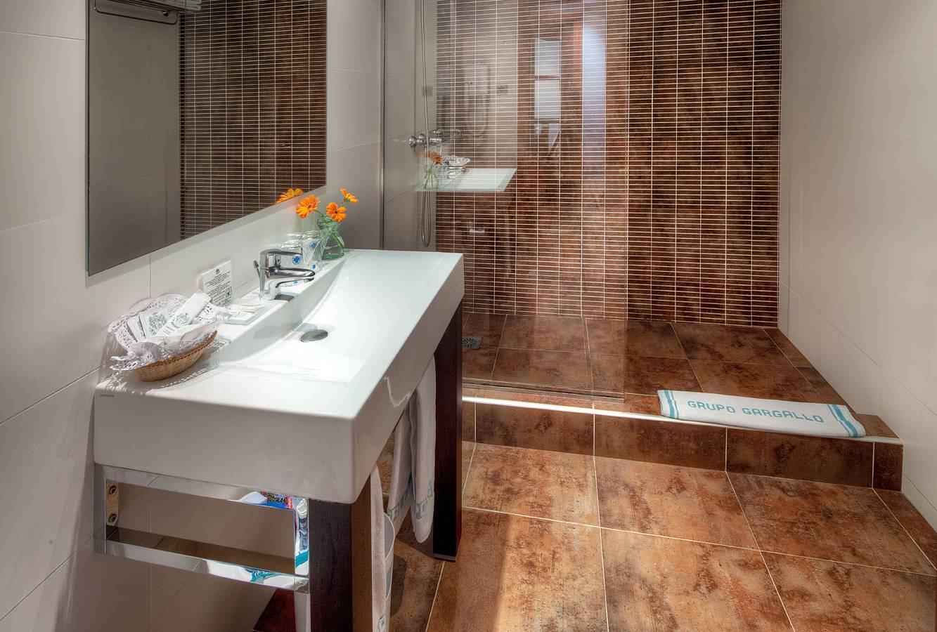 Badezimmer im Gargallo Rialto Hotel mit Dusche, Waschbecken und Spiegel.