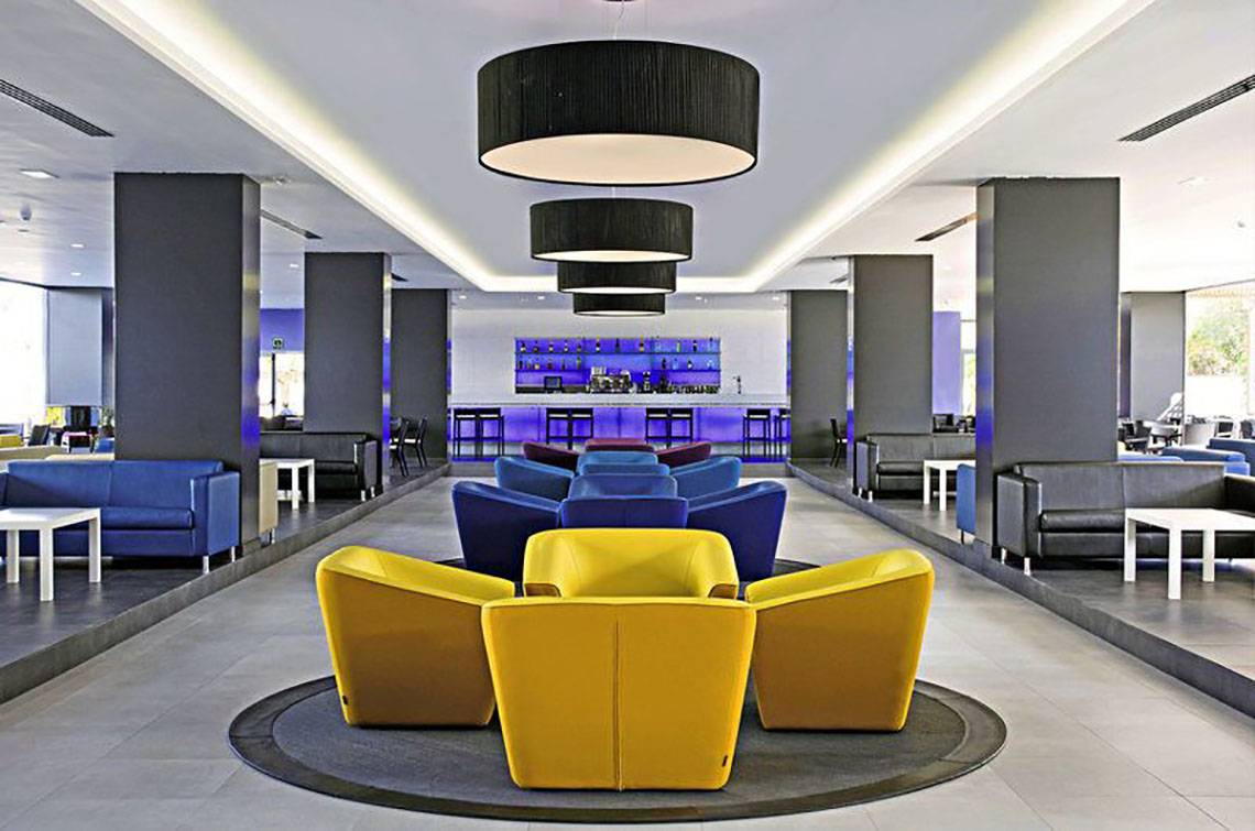 Lobby des Gran Canaria Princess Hotels mit bunten Sitzgruppen und Bar im Hintergrund.